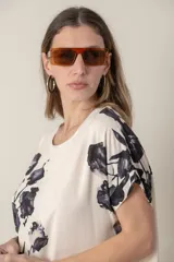Blusa italiana de calce holgado, talle único, con cuello redondo y mangas cortas. Estampado de flores sobre fondo natural.