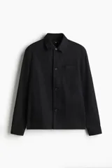 Sobrecamisa negra de manga larga con cuello inglés, tapeta lisa, canesú en la espalda y bolsillo superior de parche.
