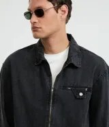 Campera de jean azul oscuro, corte boxy, con cuello inglés, cierre frontal con cremallera, manga larga y bolsillo con cierre en el pecho.