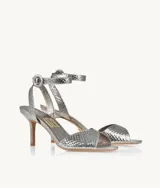 Sandalias plateadas con textura de piel de serpiente, tira delgada sobre los dedos, pulsera con hebilla al tobillo y taco fino.