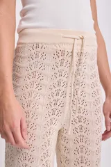 Pantalón de punto crochet color crudo, de corte recto y cintura alta con cordón ajustable.