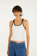Musculosa blanca de algodón con tirantes finos y ribete negro en escote y sisas.
