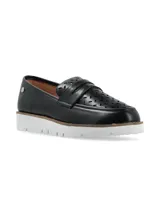 Mocasín de cuero negro con perforaciones decorativas y suela blanca de plataforma.