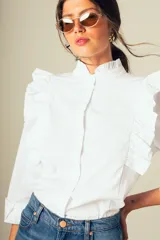 Camisa blanca de mangas largas con volados en los hombros y cuello mao.