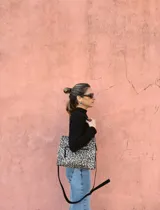 Cartera bandolera Shill Mini de cuero con estampado animal print, forro de tela y correa larga negra regulable. Cuenta con bolsillo frontal con cierre y bolsillo interno. Fabricación nacional.