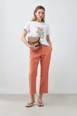 Remera blanca de algodón con cuello redondo y mangas cortas. Estampa frontal con bordado de flores y frase 'Just keep flowing'.