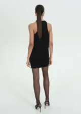 Vestido corto negro con cuello halter, espalda descubierta y abertura lateral. Incluye cinturón dorado.