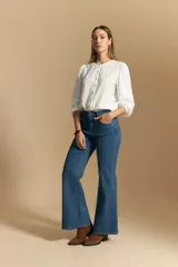 Jean oxford de tiro alto, color azul oscuro, con costuras frontales marcadas y corte acampanado progresivo desde la rodilla.