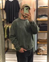 Buzo verde con efecto nevado gastado, corte oversized y cuello redondo.