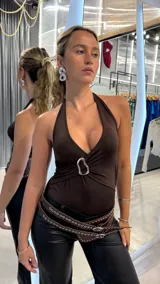 Body marrón con escote halter y detalle de aro metálico en el centro.
