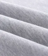 Buzo tipo canguro de color gris melange, con capucha, bolsillo canguro frontal y puños y bajo acanalados. Corte recto.