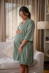 Bata tipo kimono de algodón color blanco hueso, con textura acanalada vertical. Presenta un cruce frontal asegurado con un lazo a la cintura y mangas anchas de largo al codo.