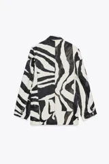 Blazer con estampado animal en blanco y negro, cuello solapa de muescas y manga larga acabada en abertura y botones. Bolsillos con solapa en delantero y de vivo en pecho. Cierre frontal cruzado con botones.