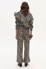 Pantalón de lino estampado con flores pequeñas en tonos crema y marrón sobre fondo azul marino. El pantalón es de tiro medio y tiene un corte ligeramente ancho en las piernas.