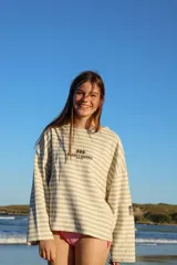 Buzo de manga larga reversible. Un lado es color arena con rayas horizontales marrones y el otro lado es azul marino liso.