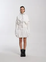 Campera blanca estilo bomber con cuello alto, cierre frontal y mangas desmontables.