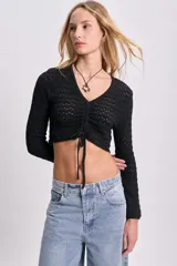 Cardigan corto de punto calado color negro, con escote en V y cierre frontal con lazo.