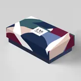 Billetera rectangular con cierre de cremallera, confeccionada en símil cuero con franjas horizontales en tonos blanco, gris y negro.