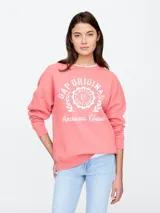 Buzo deportivo color salmón con logo Gap estampado en blanco.