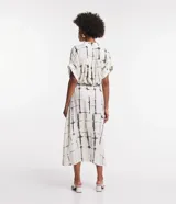 Vestido midi de viscosa color blanco con estampado de bloques negros, corte evasé, mangas cortas, cuello camisero, lazo en la cintura y cierre frontal con botones.