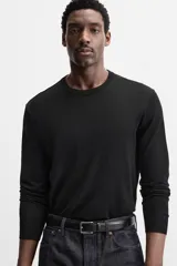 Jersey negro de lana con acabado mercerizado, corte relaxed fit, cuello redondo y manga larga con terminaciones en rib.
