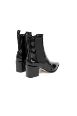 Botas negras de cuero charol, con elásticos laterales, punta ligeramente afilada y tacón bloque de 6 cm.