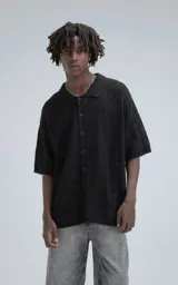 Camisa negra de manga corta tejida de punto abierto con calce oversize.