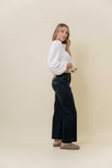 Jean de corte recto y tiro medio en color azul oscuro. Presenta un diseño clásico de cinco bolsillos, cierre frontal con botón y cremallera, y pasacintos.