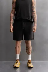 Bermudas jogger negras confeccionadas en tejido de algodón con interior de rizo. Cintura elástica ajustable con cordón y bolsillos laterales en la cadera.