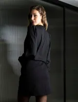Blusa negra de gasa marca Tahari, con escote en V, apliques de botones y detalle de punto smock en hombro y puño.