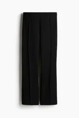 Pantalón negro de sarga con tiro alto, elástico oculto en la cintura y cierre lateral oculto. Piernas ajustadas con bajo levemente acampanado.