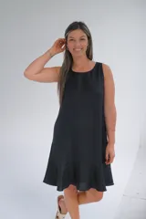 Vestido midi negro sin mangas, con escote redondo y volado en el ruedo.