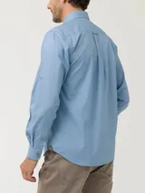 Camisa de manga larga color verde claro, confeccionada en popelina de algodón orgánico. Cuenta con cuello camisero, botones de madera, bolsillo en el pecho con logo bordado y protección UPF +20.