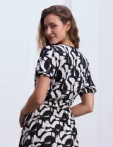 Vestido midi estampado con flores color celeste y beige, escote cruzado, mangas cortas con puños elastizados, cintura elastizada con lazo de ajuste.