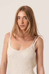 Vestido corto tejido color crudo, con breteles finos y espalda con tiras regulables.