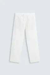 Pantalón blanco de corte recto y estilo casual, confeccionado en mezcla de algodón y lino. Cuenta con cintura elástica ajustable con cordón, bolsillos frontales y traseros de vivo.
