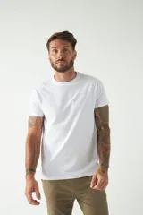 Remera básica color marrón claro, de corte regular, manga corta, cuello redondo y logo bordado en el pecho.