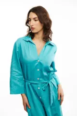 Vestido camisero midi color celeste, confeccionado en lino, con cuello camisero, botones frontales de nácar y lazo en la cintura.