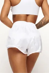 Short deportivo blanco con short interno ajustado. El short externo es de tejido liviano y el interno de poliamida con bolsillos laterales.
