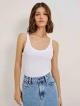 Musculosa slim color ocre, de tela acanalada con cuello redondo y sisas anchas.