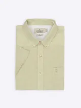 Camisa de manga corta color verde claro, confeccionada en lino y algodón. Tiene cuello abotonado, bolsillo en el pecho con logo bordado y corte clásico.