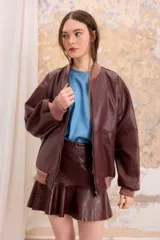 Campera bomber retro de cuero vacuno color borgoña, con cierre delantero, bolsillos y puños, cuello y pretina de algodón tejidos. Forrada en algodón y de corte oversized.