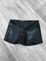 Short negro de cuero sintético, tiro bajo y corte ajustado.