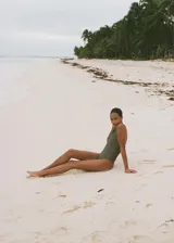 Traje de baño entero verde oliva con escote en V y tirantes anchos cruzados en la espalda.