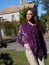 Camisa de terciopelo color púrpura con cuello clásico, cierre frontal con botones, dos bolsillos de parche en el pecho y puños con botones.