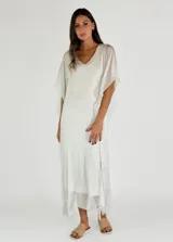 Vestido largo color crudo, de corte holgado, con escote en V y mangas cortas amplias.