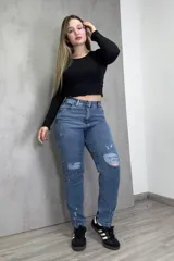 Pantalón de jean azul de corte mom con roturas en las rodillas.