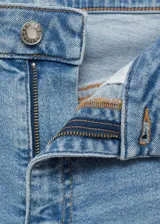 Jeans de tiro alto color celeste, corte flare, con cierre de cremallera y botón, cinco bolsillos, bajo deshilachado y tejido elástico.