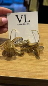 Aros colgantes dorados con forma de flor calada.