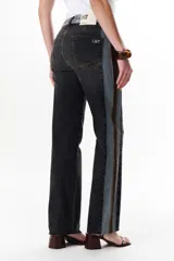 Pantalón de jean azul con paneles en distintos tonos de azul y marrón, corte recto y terminación desflecada.